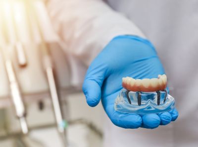 a dentist shows a full bridge denture to a patient